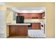 Kitchen with dark wood cabinets, black appliances, and a breakfast bar at 4243 Oak Loop # 35, Mulberry, FL 33860