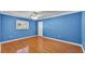 Blue-walled bedroom with wood floors and a ceiling fan at 809 Fairlane Dr, Lakeland, FL 33809