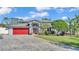 Beautiful home with red garage door, landscaping, and paved driveway at 809 Fairlane Dr, Lakeland, FL 33809