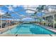 Inviting pool with screened enclosure, lake view, and grilling area at 809 Fairlane Dr, Lakeland, FL 33809