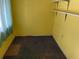 Small bedroom with yellow walls, carpet, and simple shelving at 142 Park Blvd, New Smyrna Beach, FL 32168