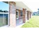 Brick patio with covered porch and grassy yard at 243 Lagoon Mist Ct, Oak Hill, FL 32759