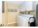 Laundry room with washer, dryer, and overhead cabinets at 4139 S. Atlantic Ave # B504, New Smyrna Beach, FL 32169