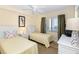 Bedroom with two twin beds, light yellow bedding, and ceiling fan at 4139 S. Atlantic Ave # B504, New Smyrna Beach, FL 32169
