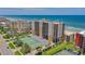 Aerial view of beachfront building with tennis courts at 4139 S. Atlantic Ave # B504, New Smyrna Beach, FL 32169