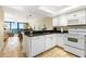 Well-equipped kitchen featuring white cabinets and granite countertops at 4139 S. Atlantic Ave # B504, New Smyrna Beach, FL 32169