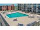 Condo rooftop pool with lounge chairs and tables at 4139 S. Atlantic Ave # B504, New Smyrna Beach, FL 32169