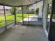 Screened patio with concrete flooring and wooden bench at 4513 Saxon Dr, New Smyrna Beach, FL 32169