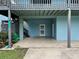 Elevated home with light blue siding, a large deck, and a spacious driveway at 6468 Engram Rd, New Smyrna Beach, FL 32169