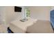 Bright bedroom with a blue upholstered bed and a window overlooking nature at 6468 Engram Rd, New Smyrna Beach, FL 32169