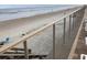 Oceanfront view with sandy beach, railing, and stairs leading down at 4811 Saxon # A201, New Smyrna Beach, FL 32169