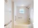 Accessible bathroom with shower and tub, grab bars, and tiled walls at 5300 S Atlantic Ave # 9201, New Smyrna Beach, FL 32169