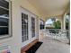 Covered balcony with white chairs and small table at 610 S Atlantic Ave, New Smyrna Beach, FL 32169