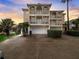 Three-story house with balconies, a large garage, and lush landscaping at 610 S Atlantic Ave, New Smyrna Beach, FL 32169