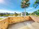Brick patio overlooking a tranquil lake with palm trees at 804 Soft Pine Ct, New Smyrna Beach, FL 32168