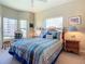 Bedroom with a queen bed, wicker nightstands, and multiple windows at 2700 N Peninsula Ave # 536, New Smyrna Beach, FL 32169