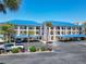 Condo building with blue roof, palm trees, and parking at 2700 N Peninsula Ave # 536, New Smyrna Beach, FL 32169