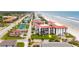 Aerial view of condo building near beach with tennis court nearby at 3001 S Atlantic Ave # 502, New Smyrna Beach, FL 32169