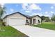 Single-story home with a two-car garage and landscaped yard at 402 Oliver Dr, New Smyrna Beach, FL 32168