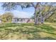 Side view of a single story home with large oak trees at 535 S Peninsula Ave, New Smyrna Beach, FL 32169