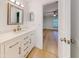 Bathroom with white vanity, quartz countertop and a view into bedroom at 6180 Olympic Ct, Port Orange, FL 32127