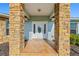 Front entry with stone columns and a white door with glass accents at 756 Bay Dr, New Smyrna Beach, FL 32168