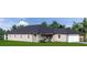 Tan one-story house with a dark roof and two car garage at 128 Indian Creek Rd, Oak Hill, FL 32759