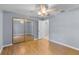 Spacious bedroom with mirrored closet doors and wood-look floors at 1328 Needle Palm Dr, Edgewater, FL 32132
