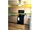 Bright kitchen with light cabinets and black appliances at 2100 N Peninsula Ave # 1050, New Smyrna Beach, FL 32169