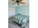Serene bedroom with striped bedding and ceiling fan at 2100 N Peninsula Ave # 1050, New Smyrna Beach, FL 32169
