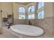 Relaxing bathroom with a spacious soaking tub and arched windows at 5090 Riverside Dr # 105, Port Orange, FL 32127