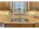 Double stainless steel sink with granite countertops and tile backsplash at 5090 Riverside Dr # 105, Port Orange, FL 32127