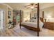 Spacious main bedroom with a large four poster bed and ceiling fan at 5090 Riverside Dr # 105, Port Orange, FL 32127