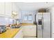 Kitchen featuring white cabinets, stainless steel refrigerator, and wood countertops at 5301 S Atlantic Ave # 630, New Smyrna Beach, FL 32169