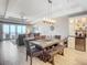 Bright dining area with a rustic wooden table and bench, seating for six, overlooking the living room and ocean view at 807 S Atlantic Ave # 302, New Smyrna Beach, FL 32169