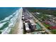 Aerial view of an oceanfront condo building with tennis courts and a pool at 4139 S Atlantic Ave # B204, New Smyrna Beach, FL 32169