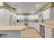Bright kitchen with white cabinets, stainless steel appliances, and a breakfast bar at 299 W Hickory Ave, Oak Hill, FL 32759