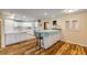 Open dining area with hardwood floors and kitchen island at 299 W Hickory Ave, Oak Hill, FL 32759