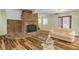 Living room with a brick fireplace, hardwood floors, and comfortable seating at 299 W Hickory Ave, Oak Hill, FL 32759