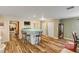Dining area with wood flooring and views into kitchen and living room at 299 W Hickory Ave, Oak Hill, FL 32759