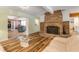 Living room with a brick fireplace, hardwood floors, and comfortable seating at 299 W Hickory Ave, Oak Hill, FL 32759