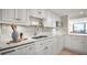 Modern kitchen with white cabinets, quartz countertops, and stainless steel appliances at 2401 S Atlantic Ave # D304, New Smyrna Beach, FL 32169