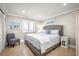 Grey upholstered king bed and a small chair in a bedroom at 2401 S Atlantic Ave # D304, New Smyrna Beach, FL 32169