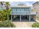Two-story beach house with balcony and covered parking, near palm trees at 6368 S Atlantic Ave, New Smyrna Beach, FL 32169