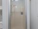 Small shower with frosted glass door and adjacent shelving at 6368 S Atlantic Ave, New Smyrna Beach, FL 32169