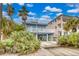 Beach house with balcony, driveway, and tropical landscaping at 6368 S Atlantic Ave, New Smyrna Beach, FL 32169