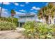 Two-story beach house with balcony and palm trees at 6368 S Atlantic Ave, New Smyrna Beach, FL 32169