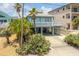 Elevated beach house with covered parking and tropical landscaping at 6368 S Atlantic Ave, New Smyrna Beach, FL 32169