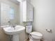 Small bathroom with pedestal sink and wood cabinet at 521 Mount Olympus Blvd, New Smyrna Beach, FL 32168