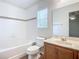 Bathroom with bathtub, toilet and wood vanity at 521 Mount Olympus Blvd, New Smyrna Beach, FL 32168